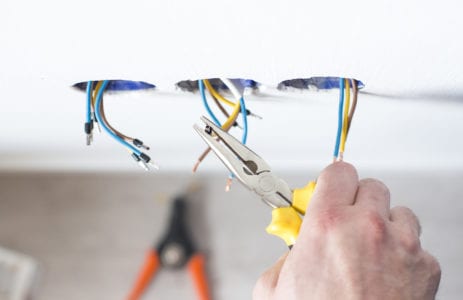 A Mister Sparky technician finishes a home electrical system repair in Oklahoma City.